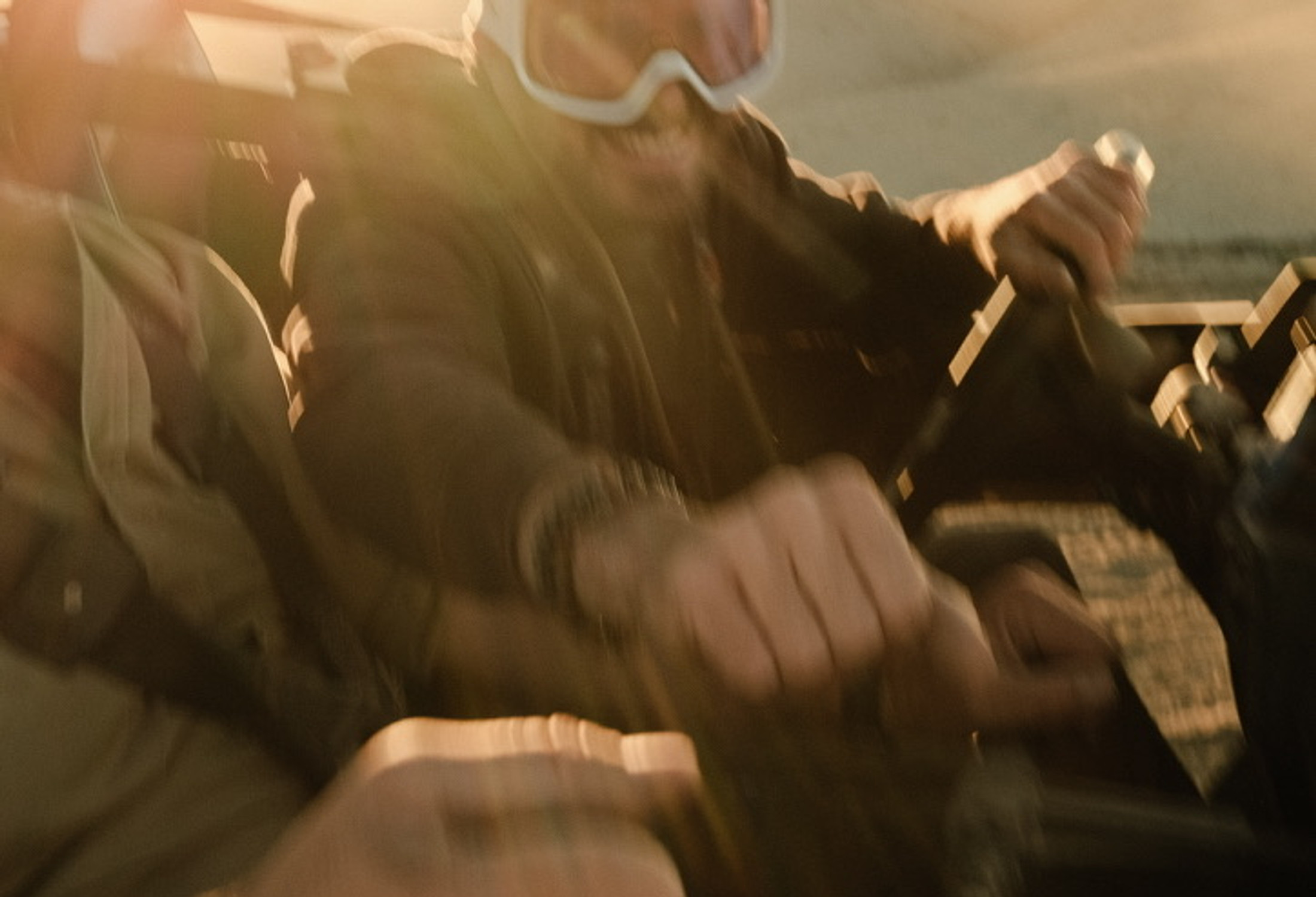 Film frame — riders in a UTV at golden hour, motion blur