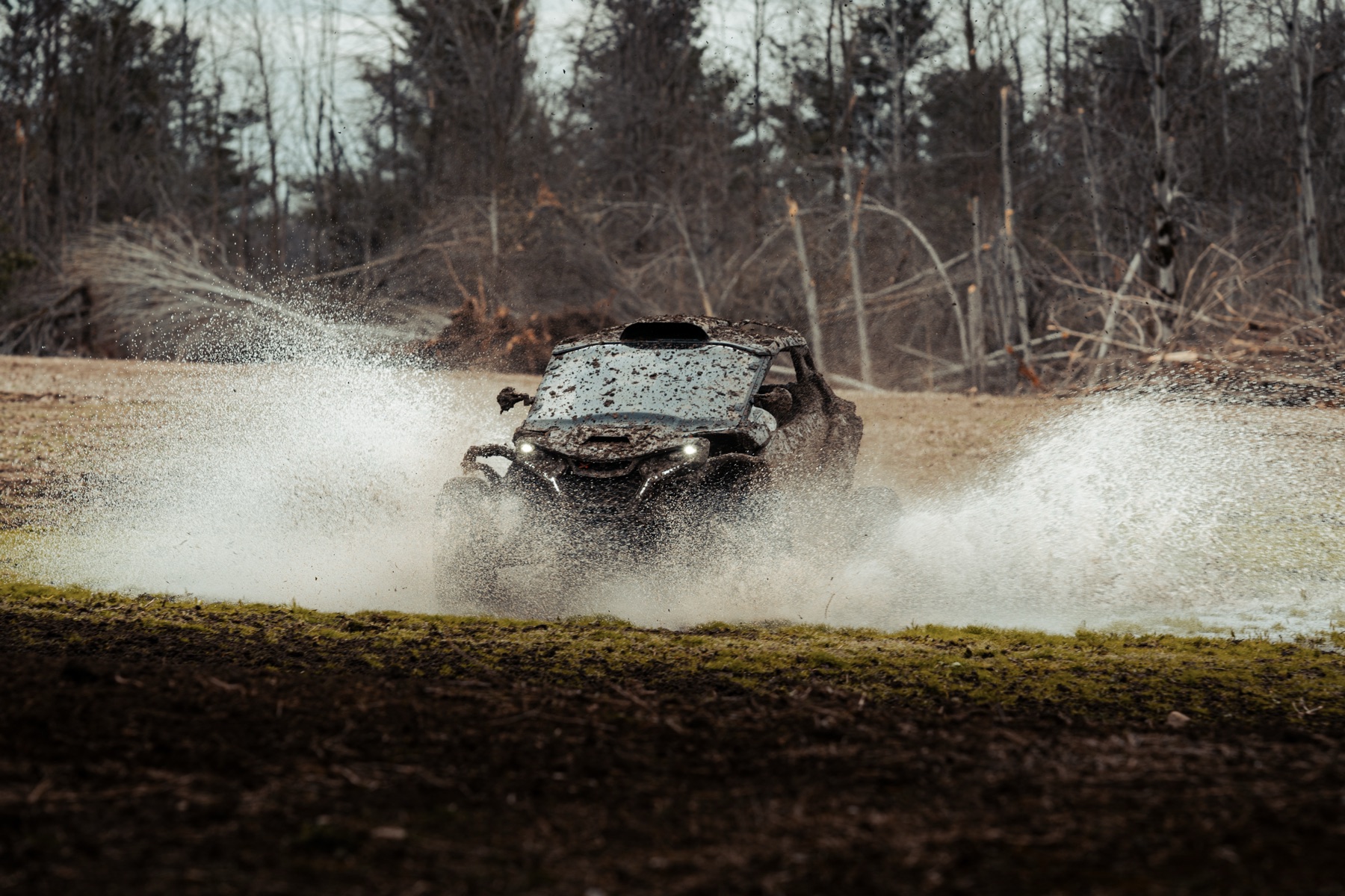 Can-Am Maverick covered in mud, mid-run